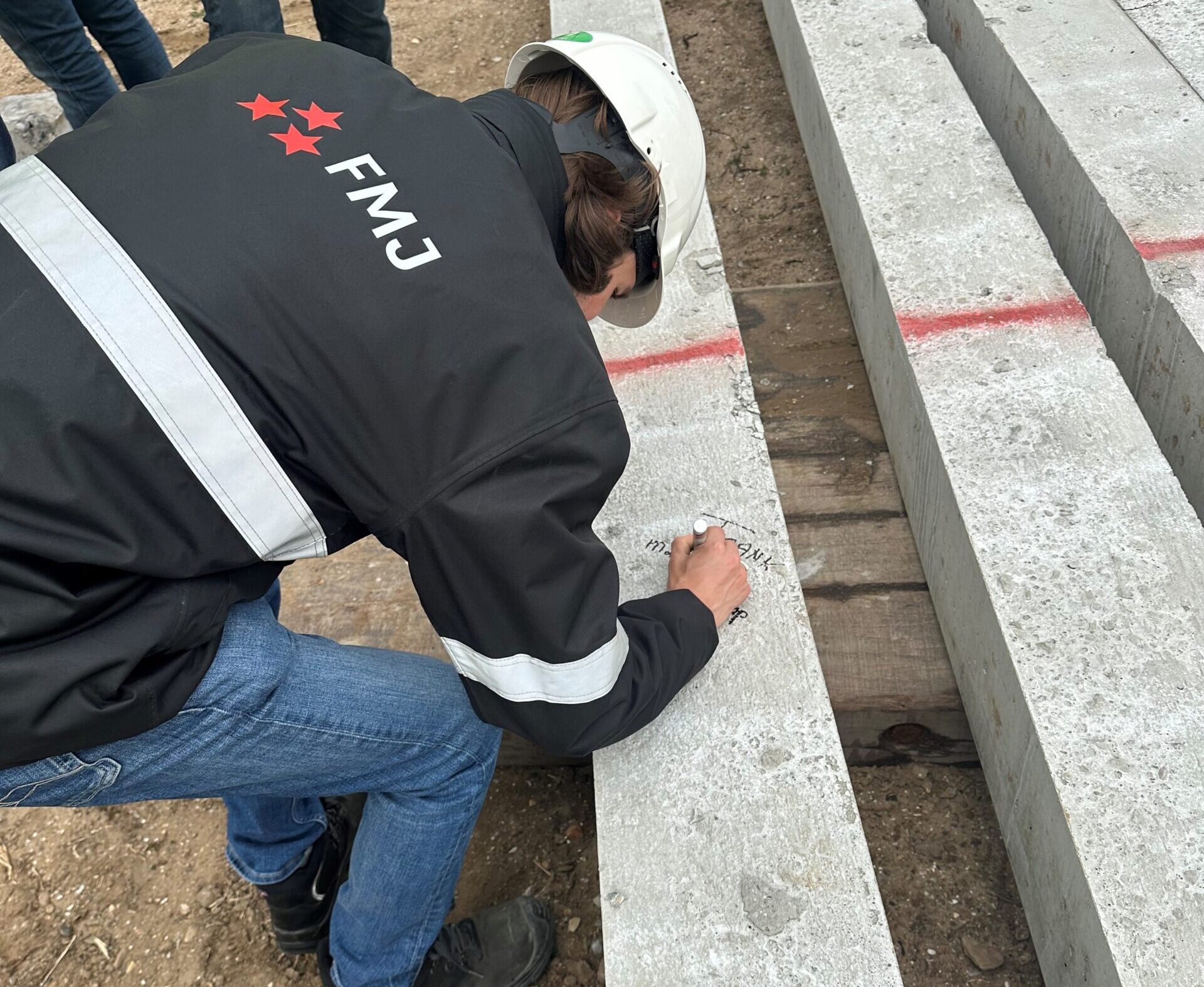 Marlon Reedijk schrijft zijn naam op een heiblok die als eerste de grond in geslagen gaat worden - Xycle Europoort Rotterdam
